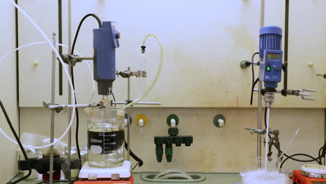 Zwei-Maschinen-Mischen-Chemische-Lösungen,-Während-Sie-Für-Ein-Experiment-In-Eis-Abkühlen-–-Aufnahme-Nach-Unten-Geneigt