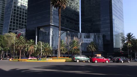 Roundabout-of-the-Palm-in-Paseo-de-la-Reforma-Avenue-with-Some-Traffic-and-Buildings-in-the-Background-on-a-Beautiful-Sunny-Day