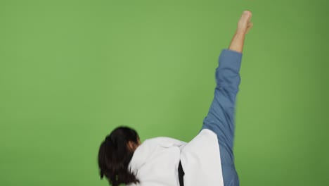Young-woman-black-belt-in-Taewkondo-shows-expert-martial-arts-moves-and-positions---green-screen-background,-slow-motion