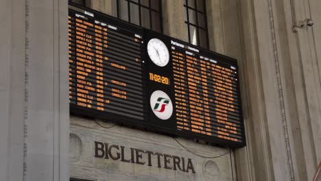 Main-display-pannel-with-train-departures-from-Milan-central-train-station,-handheld-shot