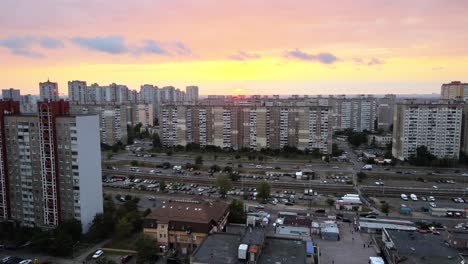 Aerial-view-of-old-buildings-and-the-tramway-rail-system,-in-Troieshchyna-soviet-district,-during-sunset,-in-Kiev,-Ukraine---pan,-drone-shot