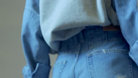 Model-wearing-high-waisted-blue-jeans,-turns-360-in-slow-motion