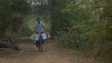 Indian-man-on-a-bicycle-riding-on-village-dirt-roads-slow-motion
