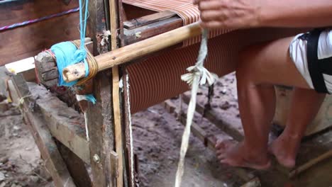 workers-weaving-thread-into-cloth-using-traditional-looms,-low-light-video-in-a-dark-room,-Pekalongan