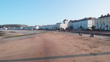 People-relaxing-on-the-beach-in-the-late-afternoon,-Llandudno,-Wales