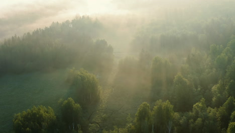 Aerial:-amazing-sunrise,-sun-rays-through-misty-morning-clouds-over-countryside