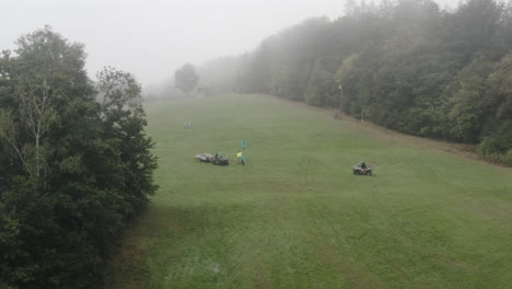 Aerial-Shot-Of-Person-On-Quad-Bike-And-Operating-Chairlift-On-Alpine-Ski-Hill-During-Summer