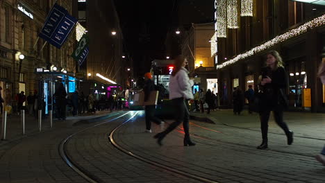 People-walk-down-the-central-street-in-Helsinki-at-night