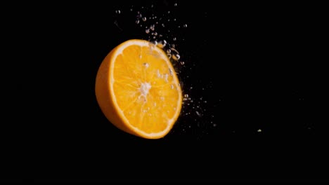 Orange-Fällt-Ins-Wasser-Super-Slowmotion,-Schwarzer-Hintergrund,-Viele-Luftblasen,-4k240fps