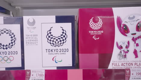 Abgesagte-Souvenirs-Zum-Thema-Olympia-2020,-Ausgestellt-Im-Offiziellen-Olympia-Laden-In-Tokio-–-Nahaufnahme,-Schwenk-Nach-Rechts
