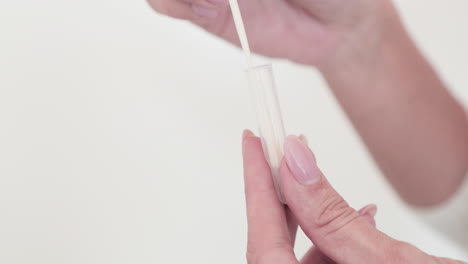 Hands-Inserting-The-Swab-Specimen-Sample-In-A-Clear-Transport-Tube---Covid-19-Swab-Sample-Testing-Kit---Closeup,-Slow-Motion