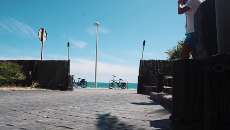 View-Of-Road-And-Calm-Ocean-From-Bar-Mar-Chica-In-Benicarlo,-Valencia,-Spain-On-A-Sunny-Day---low-level,-static-shot