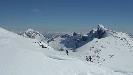 Aerial-lowering-of-a-group-of-hikers-climbing-to-the-peak-of-a-snowy-Piltriquitron-Hill,-El-BolsÃ³n,-Patagonia-Argentina