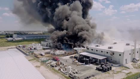 Aerial---textile-factory-fire-in-Reynosa,-Tamaulipas,-Mexico,-wide-shot-rising