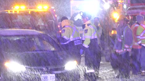 A-paramedic-talking-to-a-man-in-a-a-car-at-scene-of-accident-as-snow-falls-down-in-droves