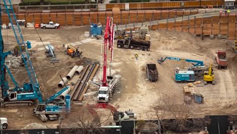 Busy-and-large-construction-site-with-cranes,-trucks-and-workers-all-in-motion---time-lapse