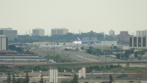 KLM-boeing--737-flight-landing-at-Toronto-Pearson-international-airport-at-midday,-other-planes-parked-by-the-landing-strip