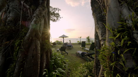 Der-Kamerawagen-Durch-Den-Banyan-Tree-Zeigt-Die-Strandszene-Bei-Sonnenuntergang