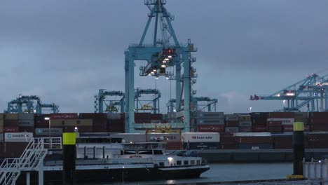 Grúa-Panamax-Levantando-Carga-Intermodal-De-Maersk-En-La-Terminal-De-Contenedores-APM-Por-La-Noche-En-Maasvlakte-Rotterdam,-Países-Bajos