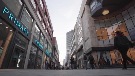 Gente-Caminando-Entre-Tiendas-Cerradas-En-La-Calle-Comercial-Rue-Neuve-En-Bruselas
