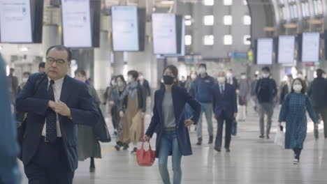Menschenmenge,-Die-Während-Der-Morgendlichen-Hauptverkehrszeit-Am-Bahnhof-Shinagawa-Jr.-Spaziert-Und-Masken-Zum-Schutz-Vor-Coronaviren-Trägt-–-Totalaufnahme,-Zeitlupe