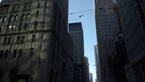 Wide-shot-travelling-along-King-Street-West,-looking-up-at-buildings-and-the-sky