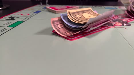 Einen-Haufen-Papiergeld-Auf-Das-Monopoly-Spielbrett-Legen