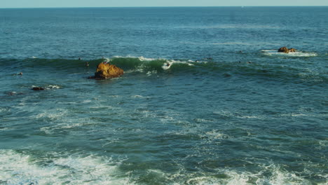 Surfers-catching-waves-and-riding-their-boards-off-the-coast-of-California