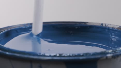 Close-up-of-plastic-stick-stirring-blue-paint