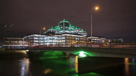 Zeitraffer-Des-Nachts-Beleuchteten-Ulster-Bank-Gebäudes-Mit-Verkehr-Auf-Der-Brücke-über-Den-Liffey-River-In-Der-Stadt-Dublin-In-Irland