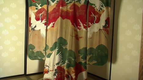 Tilt-down-on-a-kimono-hanging-in-front-of-a-fusuma-wall-in-a-Japanese-house