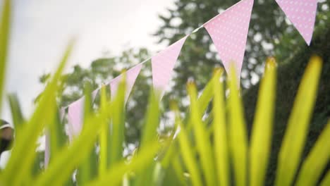 Schöne-Dreieckige-Rosa-Hängende-Flaggendekoration-In-Einer-Gartenveranstaltungsfeier-Im-Sommer