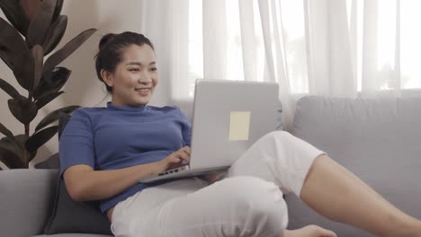 Toma-Auténtica-De-Una-Mujer-De-Negocios-Asiática-Usando-Una-Computadora-Portátil-Para-Trabajar-Felizmente-Desde-Casa
