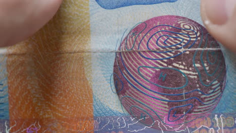 Macro-shot-of-real-one-hundred-swiss-francs-banknotes-holding-by-male-person