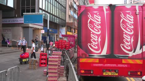 Menschen-Laufen-In-Hongkong-An-Einem-Lieferwagen-Mit-Logo-Der-Amerikanischen-Softdrink-Marke-Coca-Cola-Vorbei