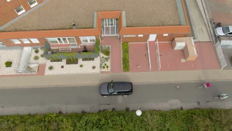 top-down-drone-shot-of-people-leaving-a-car-and-going-into-a-house