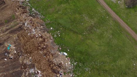 Environmental-Pollution---Plastic-Bottles,-Bags-And-Trash-In-Green-Field---aerial-shot