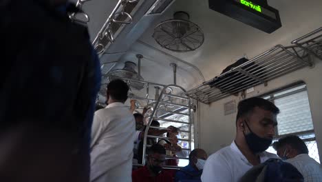 Mumbai-local-inside-passenger-seating-with-a-mask-after-covid-19-viruses-India-Mumbai-getting-down-at-Borivali