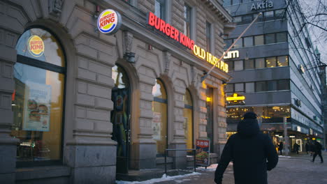 Slomo-of-Burger-King-next-to-Irish-Pub-on-Helsinki-street,-people-pass