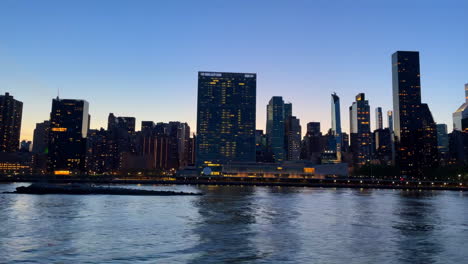 Kamera-Gleitet-über-Den-Hudson-River-Mit-Der-Silhouette-Der-Skyline-Von-New-York-City