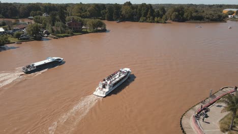 Aerial-view-of-two-catamarans-sailing-LujÃ¡n-river-at-Tigre,-Buenos-Aires