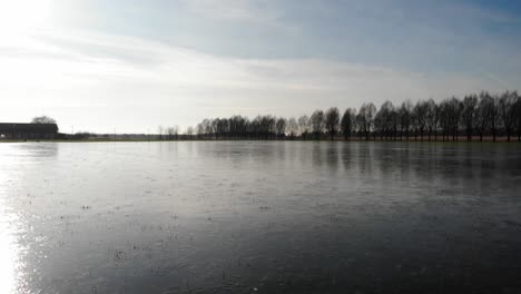 Gefrorener-Fluss-Mit-Sonnenreflexion-Bei-Sonnenuntergang-Im-Winter-In-Der-Nähe-Des-Sandelingen-Parks-In-Hendrik-Ido-Ambacht-In-Den-Niederlanden
