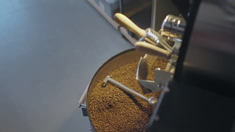 Roasting-Coffee-Beans-in-Metal-Drum-Baskets-with-Large-Metal-Furnaces,-Mixing-with-Turning-Blades-in-slowmo