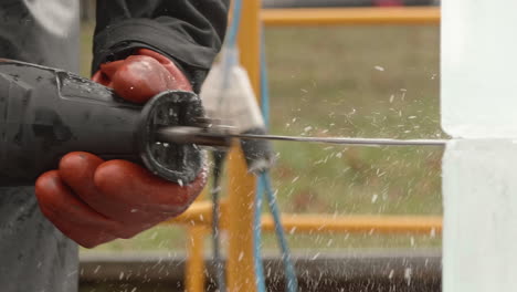 Extreme-close-up-of-reciprocating-saw-cutting-ice-block,-Slow-Motion