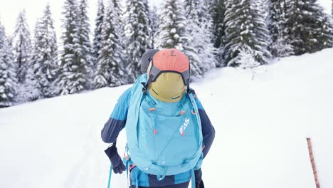 Following-skier-walking-uphill-in-snow-landscape