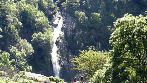 Aber-falls-Snowdonia-mountain-Welsh-national-park-waterfall-tourists-under-flowing-water