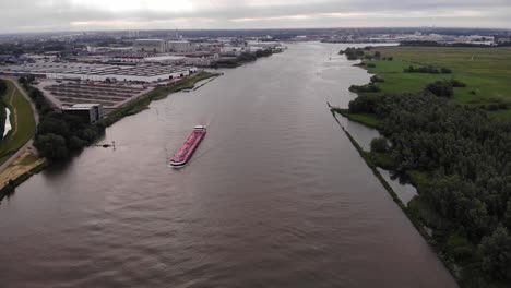 Aerial-Over-River-With-Slow-Pedestal-Down-To-Trivor-Inland-Tanker-Navigating-River