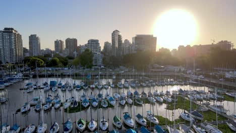 Aerial-dolly-out-of-Olivos-neighborhood-buildings-and-sailboats-parked-inline-in-port-at-sunset,-Buenos-Aires