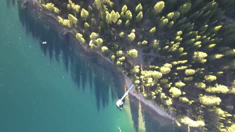 Top-down-drone-shot-of-the-water-and-forest-during-the-Golden-hour-at-Emerald-Bay-in-Tahoe-California
