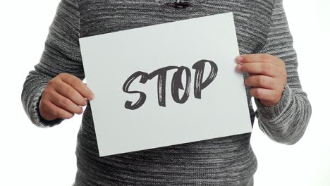 A-person-holding-a-sign-with-the-message-and-the-word-"stop
